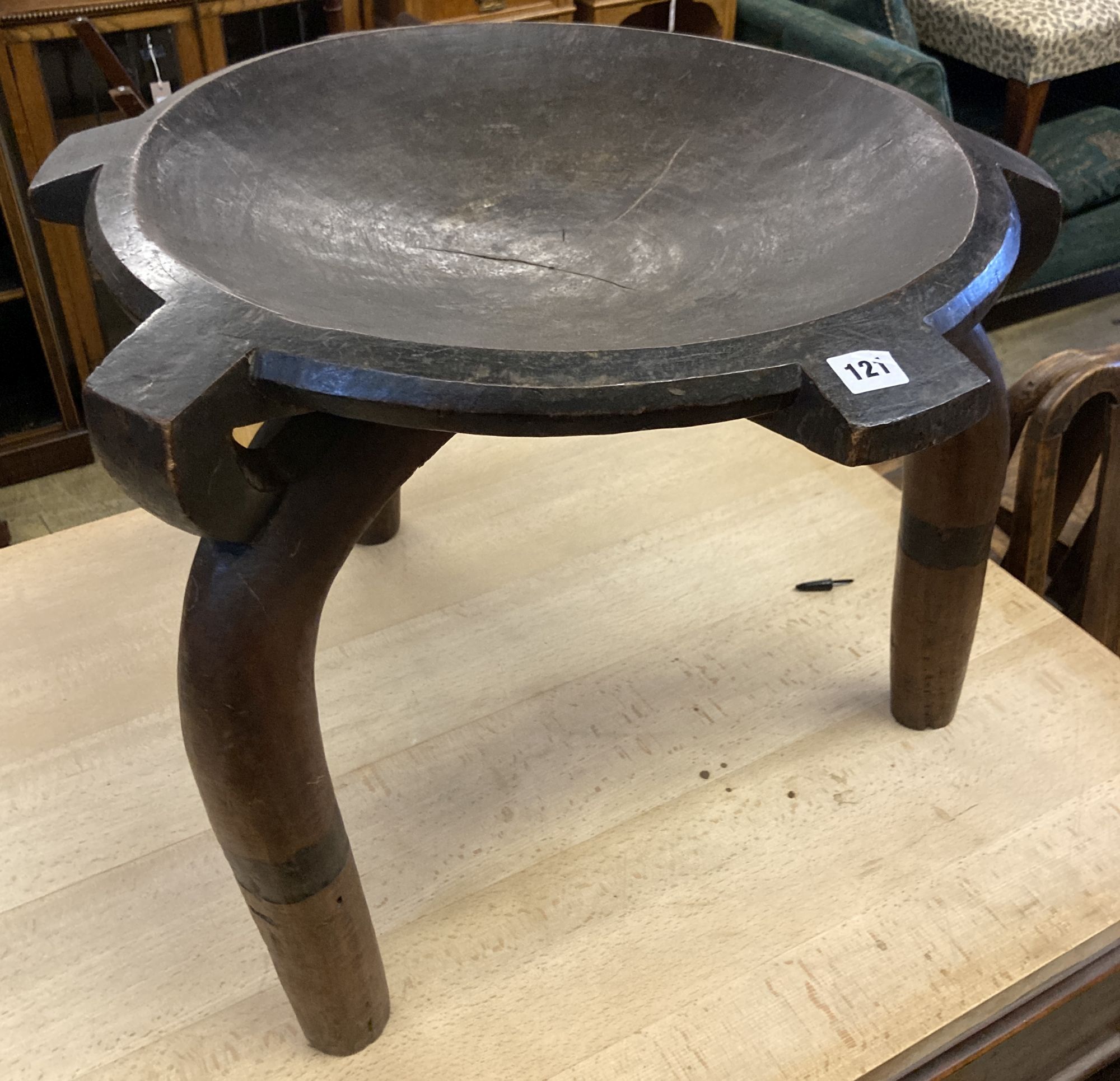An African carved hardwood bowl seat three legged stool, diameter 60cm, height 52cm
